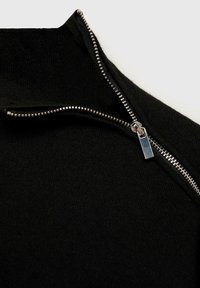 Pullover nero in maglia con collo a mezza zip. Presenta una zip argentata e un tessuto dalla superficie liscia. Design minimale con chiusura funzionale.