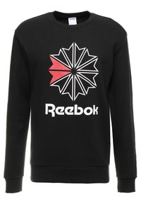 Svart sweatshirt i bomullsblandning med en grafisk stjärnexplosion i rött och vitt, där "Reebok"-texten är tydligt synlig.