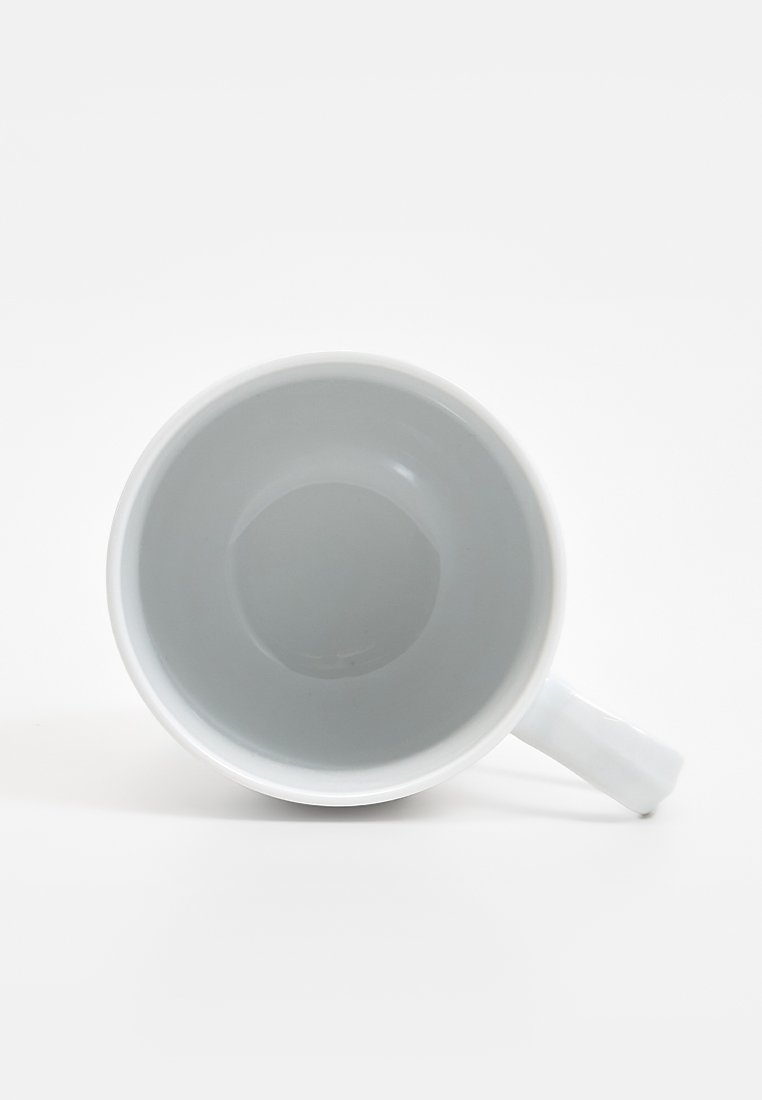 Biała ceramiczna filiżanka o gładkiej, błyszczącej powierzchni, zaokrąglonym kształcie i smukłym uchwycie; wnętrze w jasnoszarym kolorze.