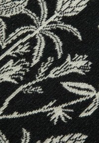 Sort stof med et hvidt botanisk mønster, der har detaljerede blade og blomster, som viser en blød tekstur og indviklede designelementer.