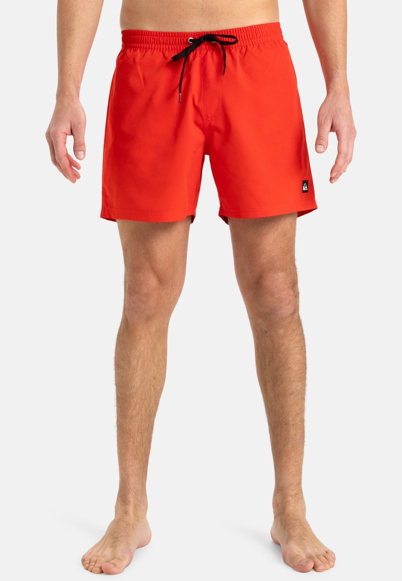 Costume de baie roșu, cu talie elastică, șnur negru și un mic logo pe lateral. Material neted și ușor.