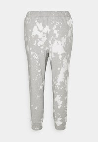 Pantalones de chándal grises con un patrón de salpicaduras blancas, cuentan con una cinturilla elástica y puños acanalados en los tobillos. Textura suave y lisa.