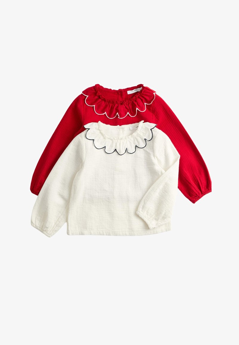 Top rosso a maniche lunghe con scollatura arricciata e top bianco a maniche lunghe sotto con bordo arricciato smerlato, entrambi in tessuto strutturato.