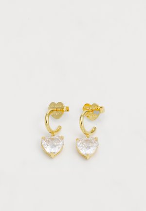 Brincos de argola em tom dourado, apresentando cristais transparentes em forma de coração, fixados com garras, e detalhe gravado no suporte.