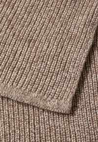 Tessuto a maglia rigata in tonalità marrone chiaro, che presenta una texture morbida e uno spessore variabile, con cuciture e dettagli dei bordi visibili.