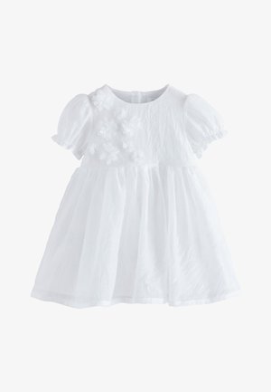 Bijela dječja haljina s kratkim napuhanim rukavima i 3D cvjetnim aplikacijama na gornjem lijevom dijelu sprijeda, detalj skupljene suknje.