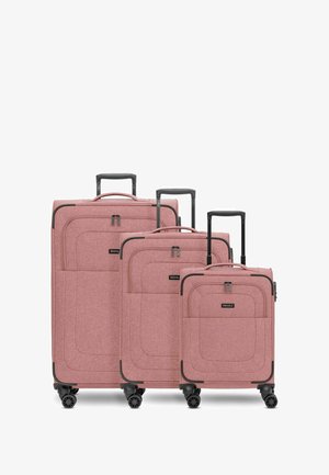 Drei pinke Stoffkoffer in unterschiedlichen Größen. Sie haben eine glatte Textur, schwarze Beschläge und vier Rollen für Mobilität.