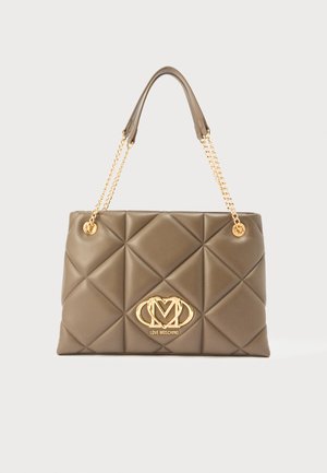 Tan quilted handbag made of synthetic material, featuring a gold chain and hardware, with a logo plaque at the front and rounded edges.