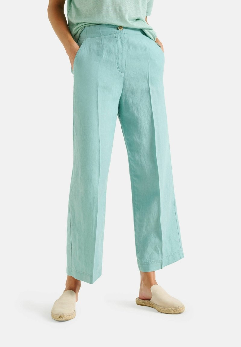 Lichtblauwe linnen wijde broek met een ontspannen pasvorm, voorzien van zijzakken en een enkele knoopsluiting bij de taille.