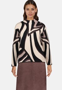 Sweter dzianinowy z abstrakcyjnym wzorem w odcieniach beżu, czerni i brązu, z wysokim kołnierzem i długimi rękawami. Miękka tekstura i luźny krój.