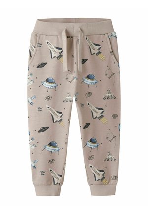 Pantaloni da jogging beige per bambini con vita regolabile a coulisse, decorati con stampe a tema spaziale di razzi, UFO, pianeti, rover e stelle.