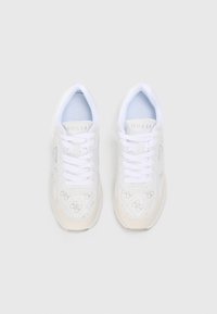 Weiße Sneakers mit strukturiertem Obermaterial und dezenten Logo-Mustern, runder Spitze, gepolsterten Zungen und flachen weißen Schnürsenkeln. Akzentuiert mit einer hellbeigen Sohle.