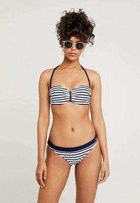 To-delt bikini med marineblå og hvite horisontale striper. Toppen har et bandeau-design med tynne stropper, og bunnen har en lav skjæring.