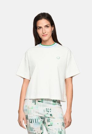 Weißes, kurz geschnittenes T-Shirt mit kurzen Ärmeln. Mit einem grünen Herz-Logo und einem mehrfarbigen gerippten Kragen. Weiche Stoffstruktur.