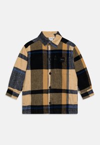 Koszula w kratkę w odcieniach żółtego, czarnego i szarego; posiada zapięcie na guziki, kołnierzyk oraz kieszeń na piersi z logo. Miękka tekstura.