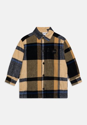 Camicia a scacchi in tonalità di giallo, nero e grigio; presenta un'apertura con bottoni, colletto e taschino sul petto con dettaglio del logo. Tessuto morbido.