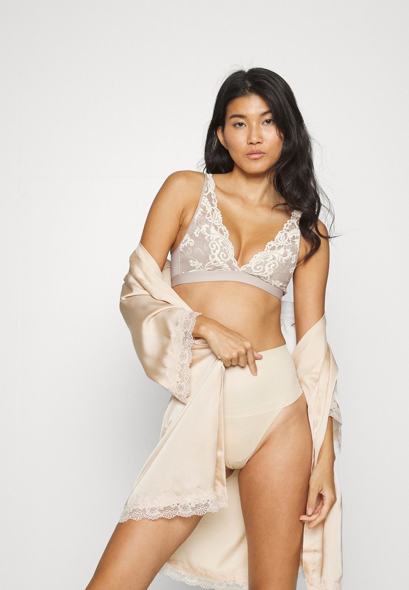 Bralett med blondedetaljer i beige, med V-halsdesign. Satengkåpe i lys beige med blondedetaljer. Høy midje nudefarget undertøy.