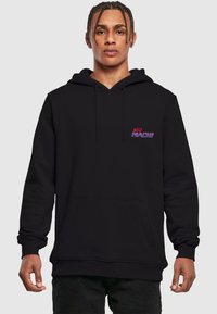 Felpa nera con cappuccio, tasca frontale e coulisse. Presenta un piccolo logo "NEO MACH" in un vivace rosa e viola sull'area sinistra del petto.