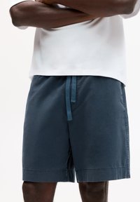 Dunkelblaue Shorts aus Baumwolle, mit einem elastischen Bund und einer blauen Kordel, glatter Textur und knielanger Passform.