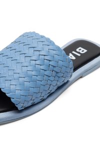 Niebieska wsuwana sandaleta z tkanej skóry z szerokim paskiem i odkrytym palcem. Okrągła podeszwa, gładka tekstura, z czarną, firmową wkładką.