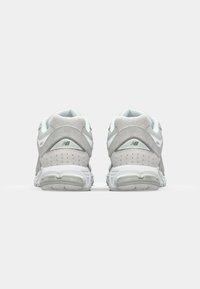 Light grey running shoes with a textured suede finish, mesh accents, and white details. Features a cushioned heel and perforated sides.