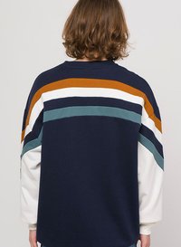 Marineblå og hvid sweatshirt med flerfarvede striber i orange, teal og creme; har en afslappet pasform og ribbet halsudskæring.