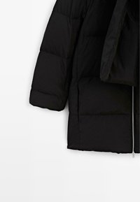 Giacca a vento nera con chiusura a zip, design trapuntato, maniche lunghe e texture morbida e imbottita. Silhouette classica e funzionale.