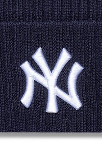 Berretto lavorato a maglia blu navy con logo dei New York Yankees ricamato in bianco. Il tessuto ha una texture a coste e una vestibilità aderente.