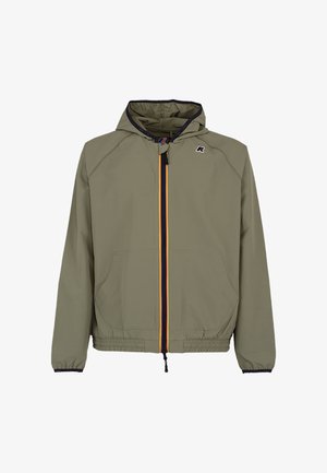 Licht olijfgroene jas met capuchon, voorzakken, elastische manchetten en zoom, en een zwarte ritssluiting met rode en gele strepen.