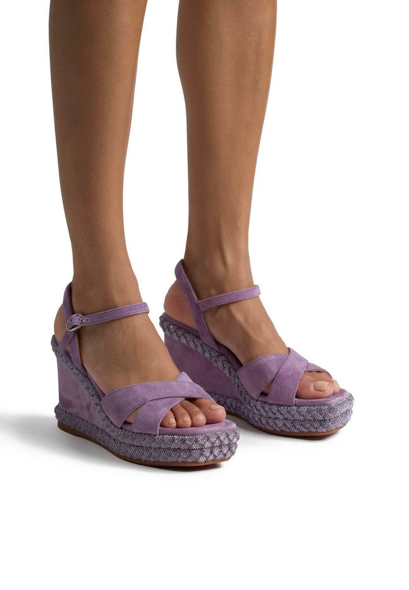 Lila Wildleder-Wedge-Sandalen mit überkreuzten Riemen, einem Knöchelverschluss und gewebten Texturelementen an der Wedge-Basis, die ein leichtes Design hervorheben.