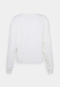 Witte sweatshirt met lange mouwen, voorzien van een textuurpatroon, geribbelde manchetten en een ronde halslijn. Heeft een klein logo nabij de hals.
