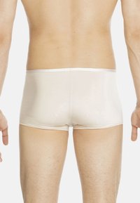 Beige men's boxer briefs with a smooth, soft texture and a low-rise fit, featuring a simple elastic waistband and seamless design.