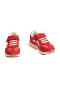 Scarpe da ginnastica rosse con tomaia in tessuto, dettagli bianchi e una chiusura in velcro. Presentano una suola ammortizzata e una suola esterna in gomma testurizzata.