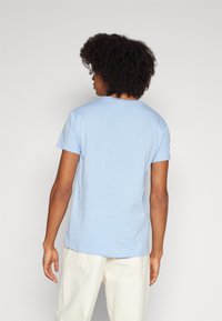 Hellblaues T-Shirt mit kurzen Ärmeln, Rundhalsausschnitt und regulärer Passform. Aus weichem Stoff gefertigt, mit glatter Textur.