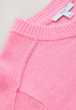 Lyserød sweater med ribbet halsudskæring og ærmekanter, blød tekstur og et enkelt design med en synlig mærkat.