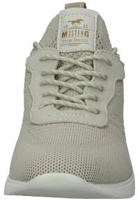 Scarpa atletica color beige chiaro con tomaia in mesh, design testurizzato, lacci piatti, dettagli sottili e suola in gomma bianca.
