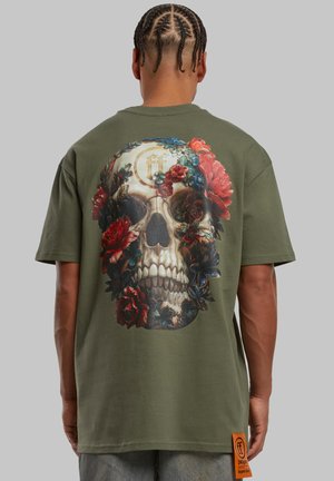 Olive green cotton T-shirt featuring a large, detailed skull surrounded by roses and leaves on the back, with orange logo tag on the side.