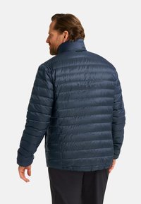 Veste matelassée bleu marine avec un col montant, une surface texturée et une silhouette ajustée, dotée de poignets élastiques et d'une finition lisse.