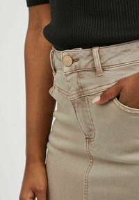 Beige džínová sukně s přiléhavým střihem, která má zapínání na knoflík, boční kapsy, šité detaily a hladkou strukturu.