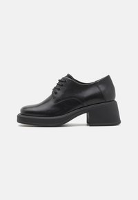 Sapatos pretos de couro com atacadores, com ponta arredondada e um salto bloco de altura média. Textura suave com detalhes de costura mínimos.