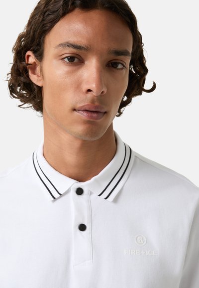 Weißes Poloshirt mit schwarzen Doppelstreifen am Kragen, schwarzen Knöpfen und dezentem Logo-Stick auf der Brust, das ein sauberes und klassisches Design betont.