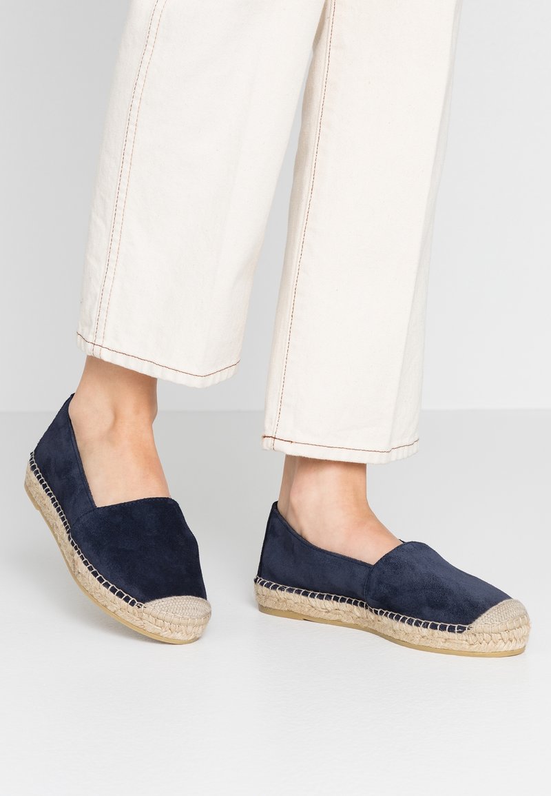 Námořnické semišové espadrilky s pletenou jutovou středovou částí a prošívanými detaily. Uzavřená špička s hladkým povrchem a minimalistickým tvarem.