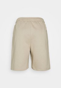 Shorts en coton beige avec une texture lisse, taille élastique et deux poches latérales. Design simple, longueur mi-cuisse.