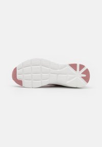 Sneakersula i vit och rosa gummi, som har texturerade mönster för grepp, en slät yta och tydliga fåror för fäste.