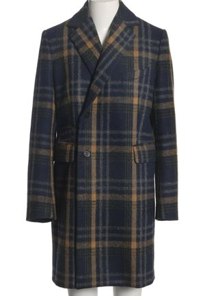 Manteau en laine à carreaux bleu foncé et marron avec revers crantés, deux boutons sur le devant, poches à rabat et manches longues sur un mannequin.