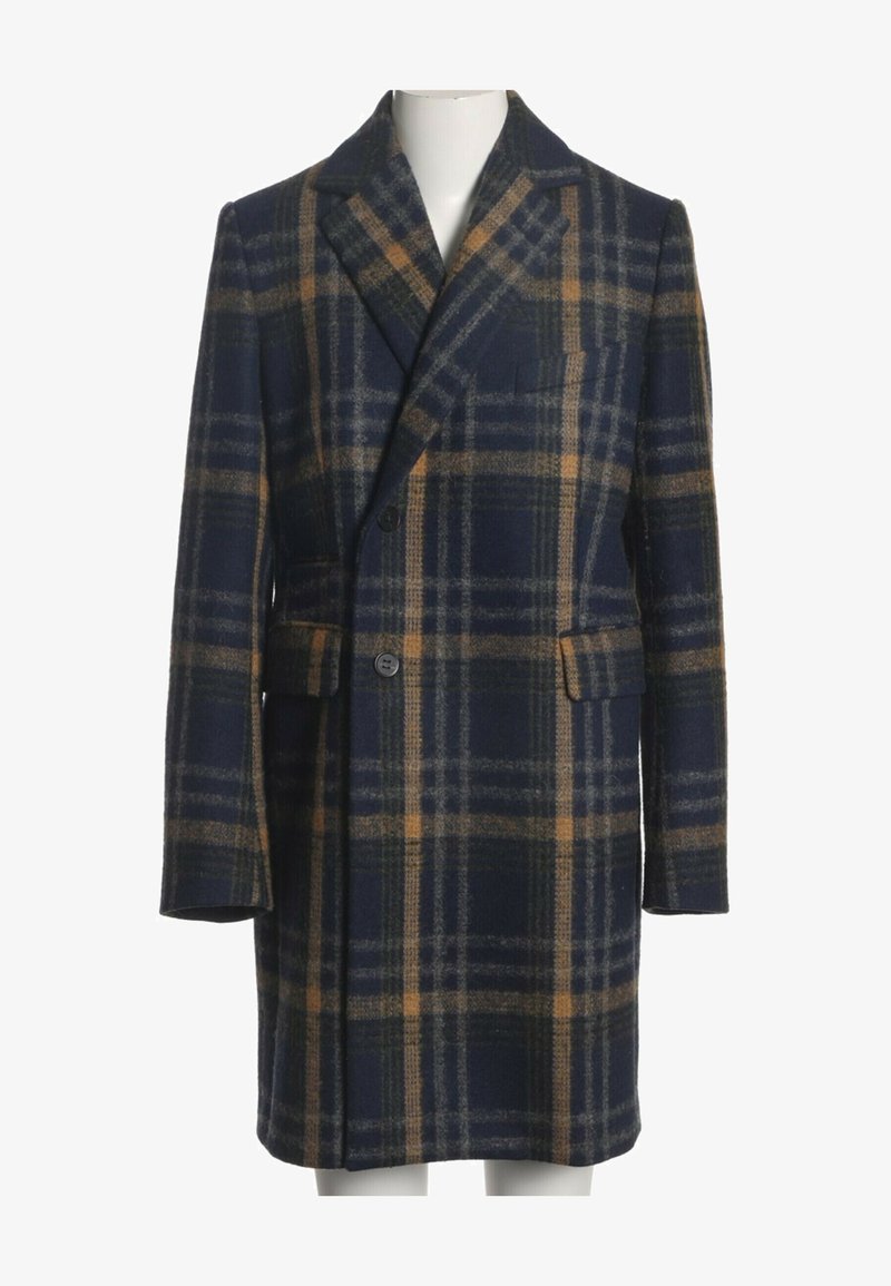 Manteau en laine à carreaux bleu foncé et marron avec revers crantés, deux boutons sur le devant, poches à rabat et manches longues sur un mannequin.