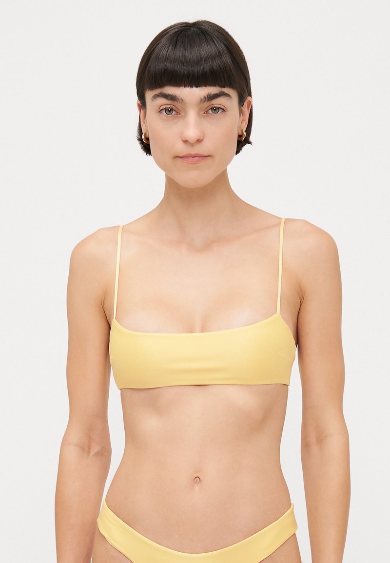 Yellow bikini top with a smooth texture, rectangular cut, and thin straps, paired with matching bikini bottoms.