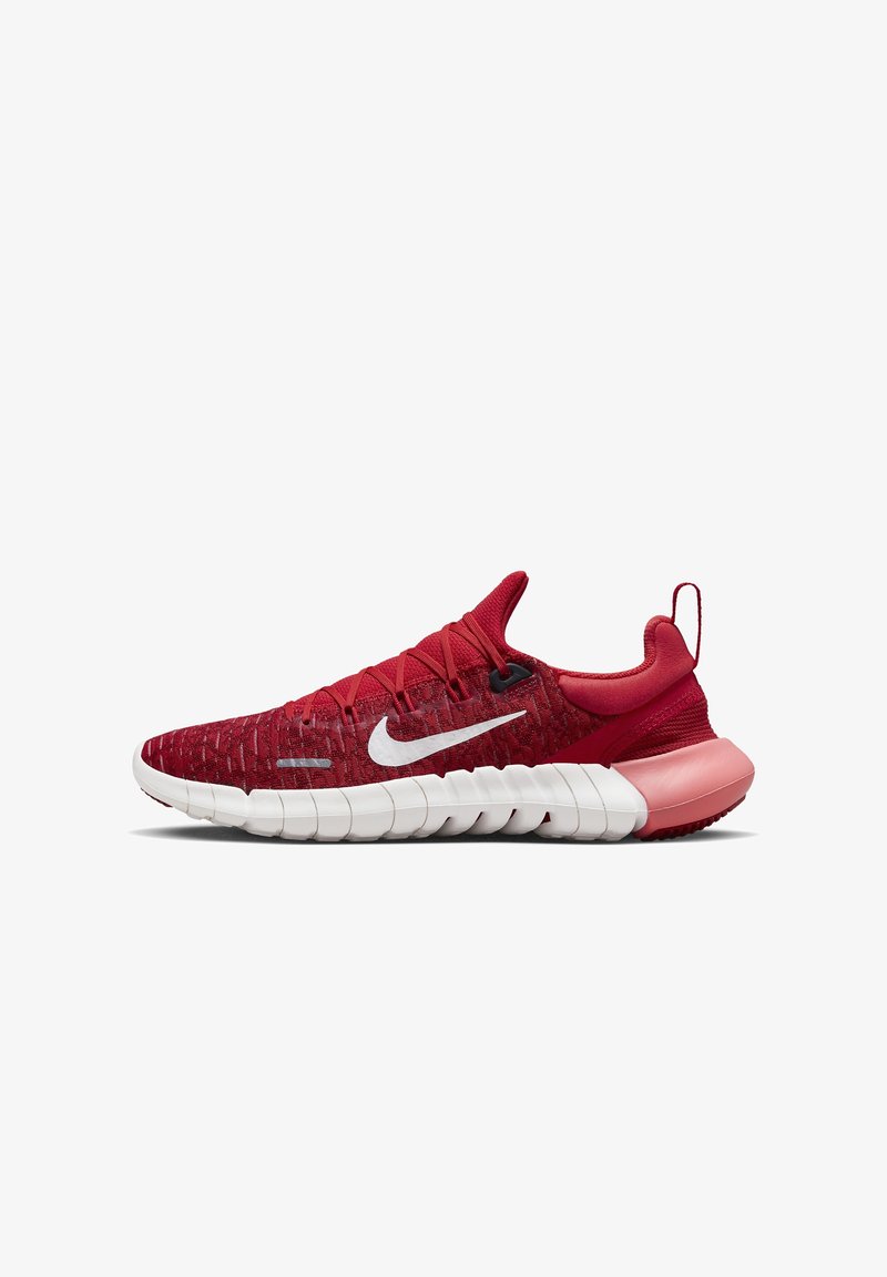 Chaussure de course Nike rouge avec logo swoosh blanc, semelle segmentée blanche et languette de soutien du talon rose sur fond blanc.