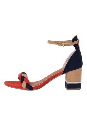 Blokhak sandaal met een gevlochten, veelkleurige band in rood, marineblauw en tan suede, met een beige enkelband en een contrasterende blokhak.