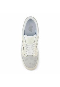 White and gray sneaker featuring a textured suede toe, mesh tongue, and perforated details. Laces and branding on the insole are visible.